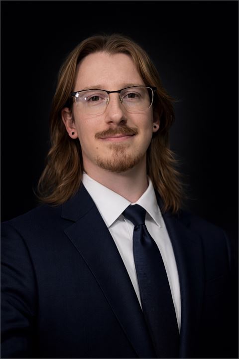 Garrett Lester, Realtor® with Great Lakes Real Estate — professional headshot in a navy suit.