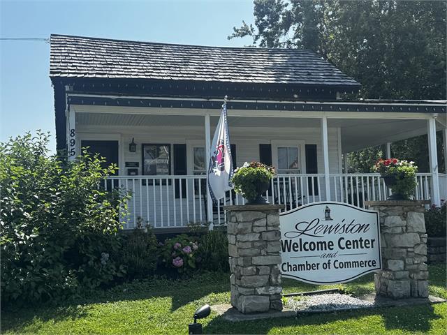 The historic Lewiston Welcome Center and Chamber of Commerce building, a white cottage with a covered porch and stone sign.